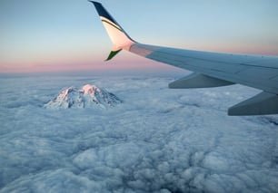 Plane above the clouds and mountains. 